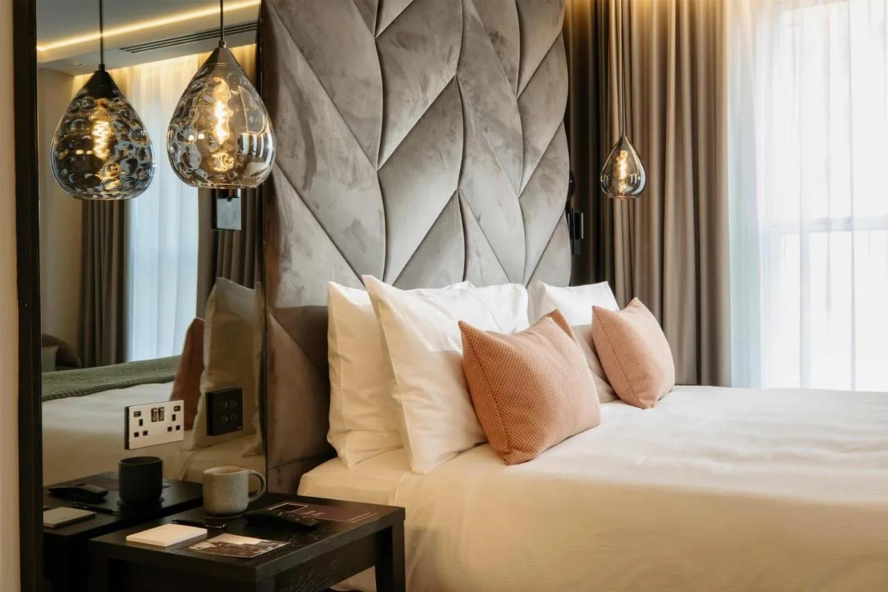 A bedroom with pillows and a mirror at The Wellington Glasgow by Adina, Glasgow