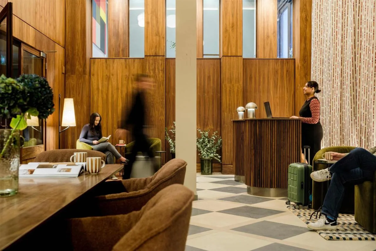 A woman at the reception podium in the lobby of The Wellington Glasgow by Adina